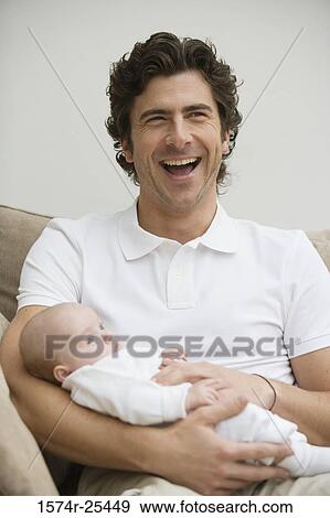 Mid adult man laughing and holding his baby View Large Photo Image Stock Photo - Mid adult man laughing and holding his baby. Fotosearch