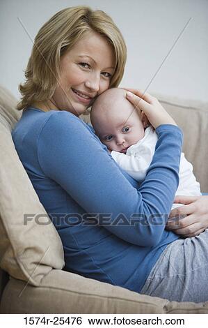 Mid adult woman embracing her baby View Large Photo Image Stock Photograph - Mid adult woman embracing her baby. Fotosearch