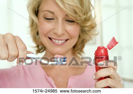 Mid adult woman holding a toothbrush and toothpaste View Large Photo Image Stock Photography - Mid adult woman holding a toothbrush and toothpaste. Fotosearch