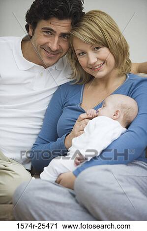 Mid adult woman holding her baby with a mid adult man sitting beside her View Large Photo Image Stock Image - Mid adult woman holding her baby with a mid adult man sitting beside her. Fotosearch