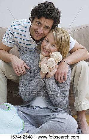 Mid adult woman hugging a stuffed animal with a mid adult man behind her View Large Photo Image Stock Image - Mid adult woman hugging a stuffed animal with a mid adult man behind her. Fotosearch