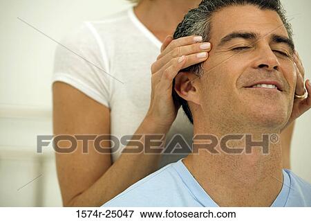 Mid adult woman massaging the temples of a mature man View Large Photo Image Stock Photo - Mid adult woman massaging the temples of a mature man. Fotosearch