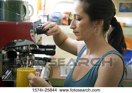 Mid adult woman operating a coffee maker in a cafe View Large Photo Image Picture - Mid adult woman operating a coffee maker in a cafe. Fotosearch