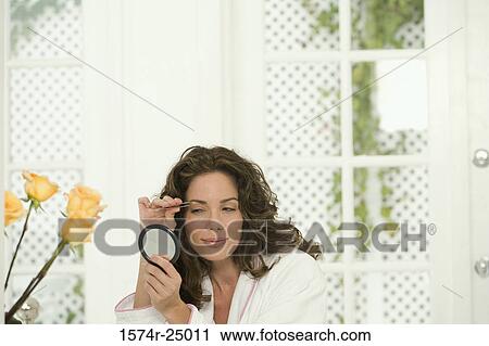 Mid adult woman plucking her eyebrows View Large Photo Image Stock Image - Mid adult woman plucking her eyebrows. Fotosearch