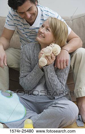 Mid adult woman sitting and holding a stuffed animal with a mid adult man behind her View Large Photo Image Stock Image - Mid adult woman sitting and holding a stuffed animal with a mid adult man behind her. Fotosearch