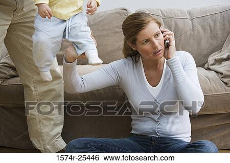 Stock Photograph - Mid adult woman using a mobile phone. Fotosearch