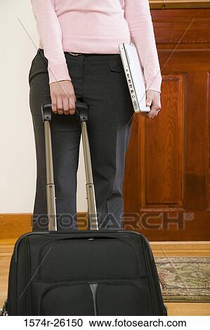 Mid section view of a businesswoman holding a luggage handle View Large Photo Image Stock Image - Mid section view of a businesswoman holding a luggage handle. Fotosearch