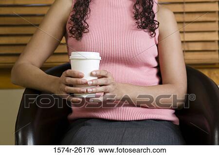 Mid section view of a businesswoman holding a disposable cup View Large Photo Image Stock Photograph - Mid section view of a businesswoman holding a disposable cup. Fotosearch