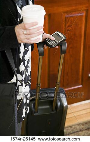 Mid section view of a businesswoman holding a personal data assistant View Large Photo Image Stock Photography - Mid section view of a businesswoman holding a personal data assistant. Fotosearch