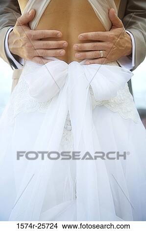 Mid section view of a groom embracing his bride View Large Photo Image Picture - Mid section view of a groom embracing his bride. Fotosearch