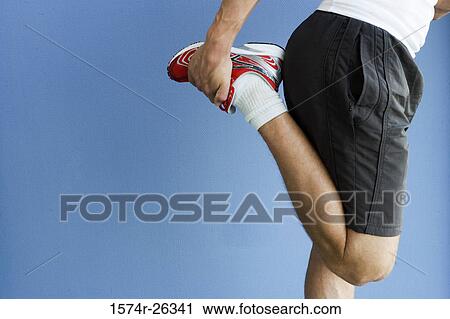 Mid section view of a man stretching his quadricep muscle View Large Photo Image Stock Image - Mid section view of a man stretching his quadricep muscle. Fotosearch