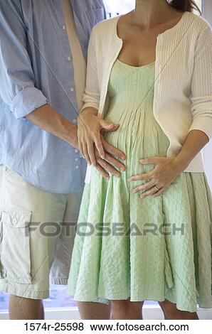 Mid section view of a man touching the abdomen of a pregnant woman View Large Photo Image Stock Photo - Mid section view of a man touching the abdomen of a pregnant woman. Fotosearch