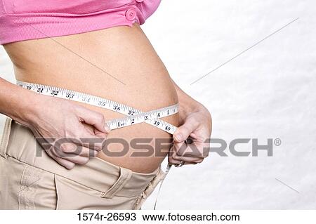 Mid section view of a pregnant young woman measuring her abdomen with a measuring tape View Large Photo Image Stock Image - Mid section view of a pregnant young woman measuring her abdomen with a measuring tape. Fotosearch