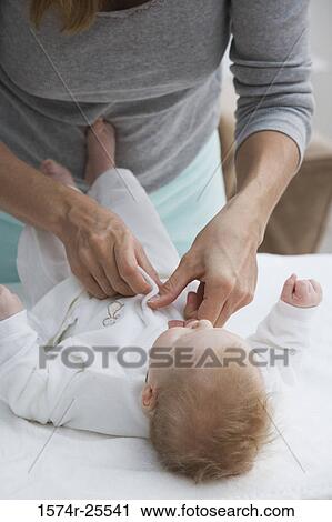 Mother putting baby clothing on her baby View Large Photo Image Stock Image - Mother putting baby clothing on her baby. Fotosearch