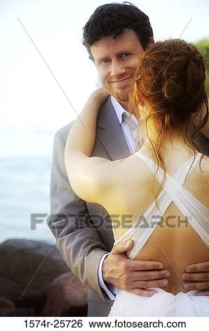 Stock Photograph - Newlywed couple embracing each other. Fotosearch