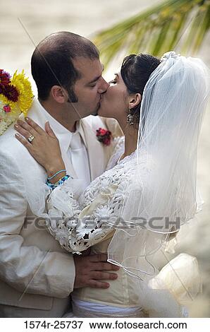 Newlywed couple kissing each other View Large Photo Image Stock Photo - Newlywed couple kissing each other. Fotosearch