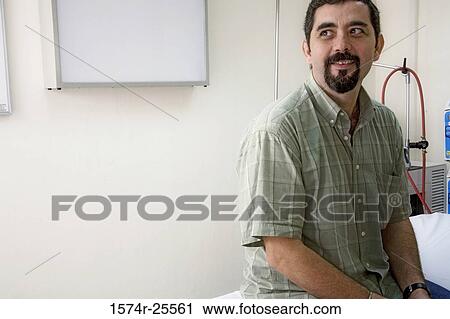Stock Image - Patient sitting in a hospital room and smiling. Fotosearch