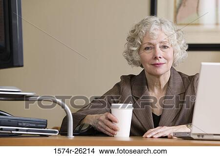 Picture - Portrait of a businesswoman sitting at a desk. Fotosearch