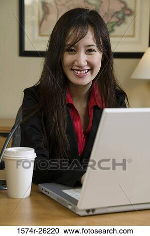 Stock Image - Portrait of a businesswoman using a laptop. Fotosearch