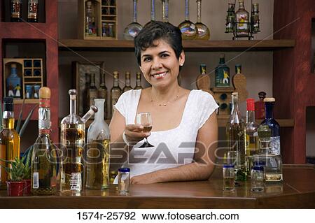 Portrait of a mature woman holding a glass of tequila and smiling View Large Photo Image Stock Image - Portrait of a mature woman holding a glass of tequila and smiling. Fotosearch