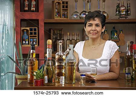 Portrait of a mature woman holding a glass of tequila and smiling View Large Photo Image Stock Image - Portrait of a mature woman holding a glass of tequila and smiling. Fotosearch