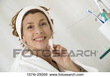 Portrait of a mature woman wiping her face with a cotton pad View Large Photo Image Stock Photo - Portrait of a mature woman wiping her face with a cotton pad. Fotosearch