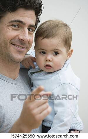 Portrait of a mid adult man holding his son and pointing View Large Photo Image Stock Image - Portrait of a mid adult man holding his son and pointing. Fotosearch