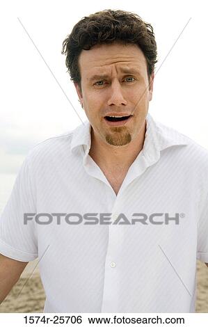 Stock Photograph - Portrait of a mid adult man looking surprised. Fotosearch