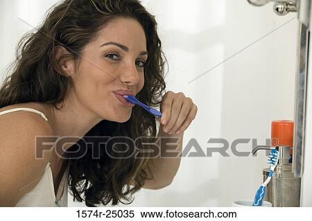 Portrait of a mid adult woman brushing her teeth View Large Photo Image Stock Photography - Portrait of a mid adult woman brushing her teeth. Fotosearch