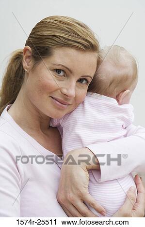 Stock Image - Portrait of a mid adult woman holding her daughter. Fotosearch