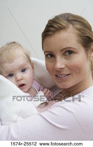 Portrait of a mid adult woman holding her daughter View Large Photo Image Stock Image - Portrait of a mid adult woman holding her daughter. Fotosearch