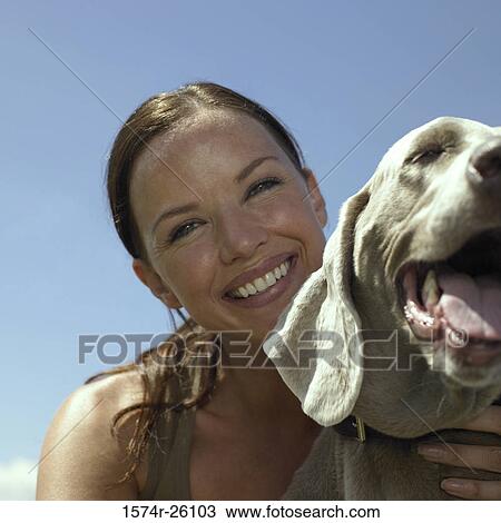 Portrait of a mid adult woman holding her dog and smiling View Large Photo Image Stock Image - Portrait of a mid adult woman holding her dog and smiling. Fotosearch