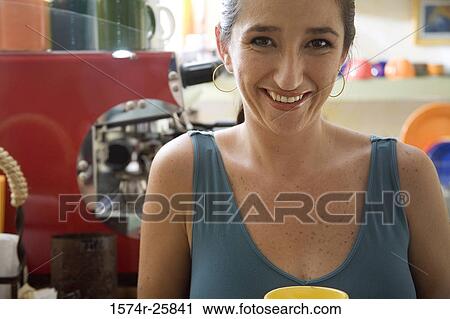 Stock Image - Portrait of a mid adult woman smiling in a cafe. Fotosearch