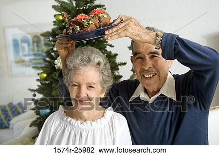 Portrait of a senior man holding a plate of Yule log shaped cake over a senior woman's head View Large Photo Image Stock Image - Portrait of a senior man holding a plate of Yule log shaped cake over a senior woman's head. Fotosearch
