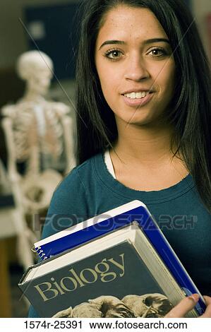 Stock Image - Portrait of a student holding books. Fotosearch