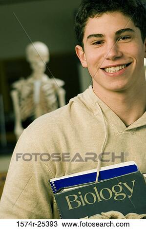 Stock Image - Portrait of a student holding books. Fotosearch