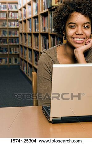 Picture - Portrait of a student sitting in front of a laptop. Fotosearch