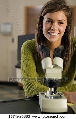 Portrait of a student sitting in front of a microscope in a sciene lab View Large Photo Image Stock Image - Portrait of a student sitting in front of a microscope in a sciene lab. Fotosearch