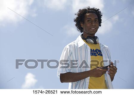 Stock Image - Portrait of a young man wearing headphones. Fotosearch