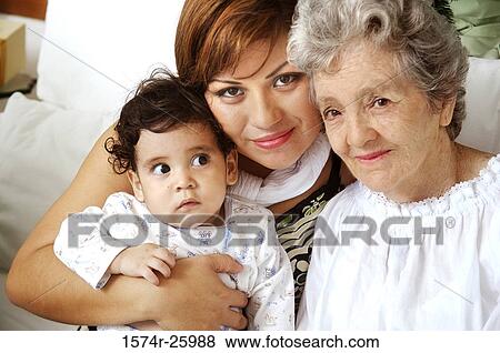 Portrait of a young woman with her baby and a senior woman sitting on a couch View Large Photo Image Stock Photo - Portrait of a young woman with her baby and a senior woman sitting on a couch. Fotosearch