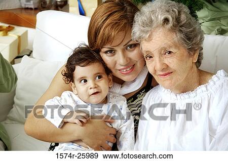 Portrait of a young woman with her baby and a senior woman sitting on a couch View Large Photo Image Stock Photo - Portrait of a young woman with her baby and a senior woman sitting on a couch. Fotosearch