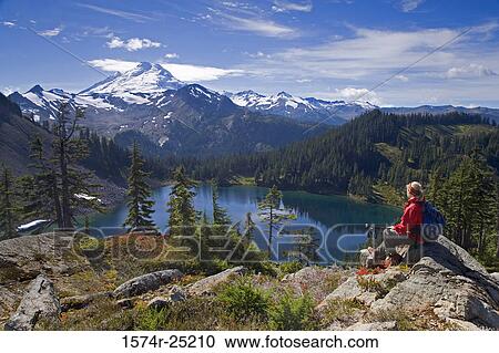 Rear view of a woman sitting on a rock View Large Photo Image Stock Image - Rear view of a woman sitting on a rock. Fotosearch
