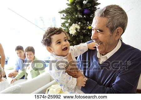 Stock Image - Senior man holding his great-grandchild and laughing. Fotosearch