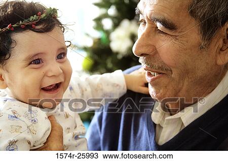 Senior man holding his great-grandchild and smiling View Large Photo Image Stock Image - Senior man holding his great-grandchild and smiling. Fotosearch