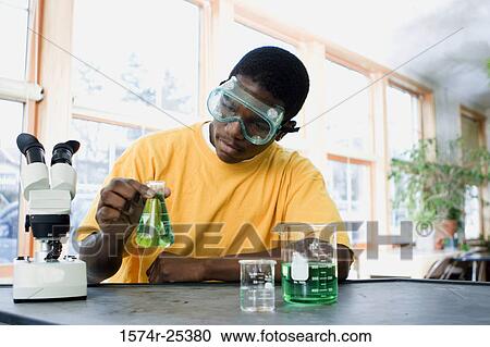 Student holding a beaker in a science lab View Large Photo Image Stock Image - Student holding a beaker in a science lab. Fotosearch
