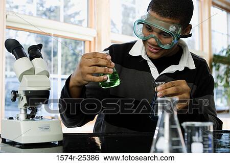 Student looking at a beaker in a science lab View Large Photo Image Stock Photograph - Student looking at a beaker in a science lab. Fotosearch