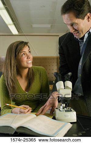 Student looking at her teacher in a science lab View Large Photo Image Stock Photography - Student looking at her teacher in a science lab. Fotosearch