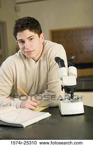 Student sitting by a microscope in a science lab View Large Photo Image Stock Image - Student sitting by a microscope in a science lab. Fotosearch