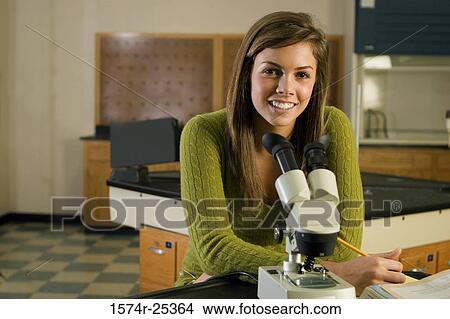 Student sitting in front of a microscope in a science lab View Large Photo Image Picture - Student sitting in front of a microscope in a science lab. Fotosearch