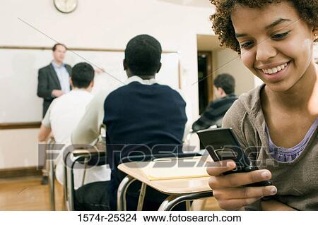 Student using a mobile phone in a classroom View Large Photo Image Picture - Student using a mobile phone in a classroom. Fotosearch